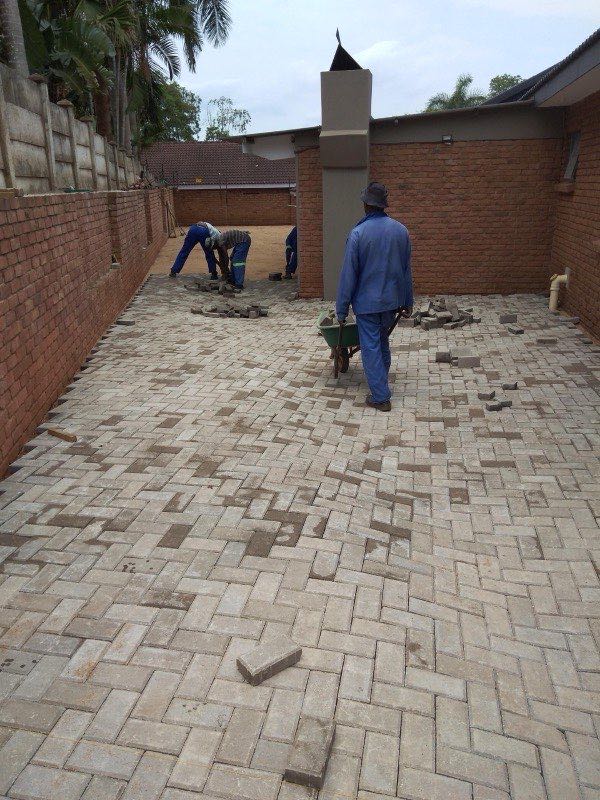 Large herringbone paved courtyard between brick walls